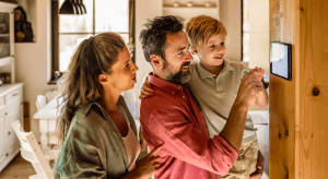 Family looking at smart thermostat on wall.
